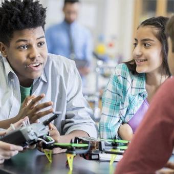 Students work with a drone in class.